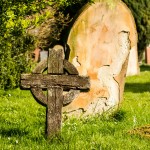 old wooden celtic cross and stone grave