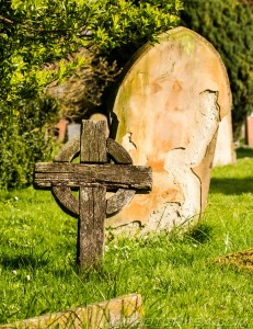 old wooden celtic cross and stone grave