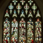 stained glass of jesus surrounded by angels and saints