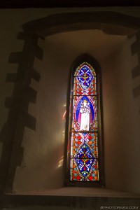 narrow slit stained glass with light shining through