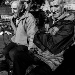 2 old blokes sitting by the pigeons
