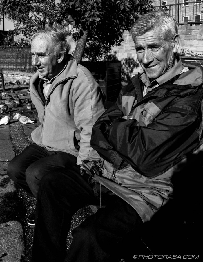 2 old blokes sitting by the pigeons