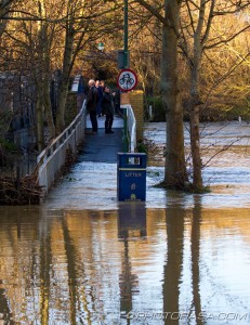 people observing the flooded river on tovil footbridge