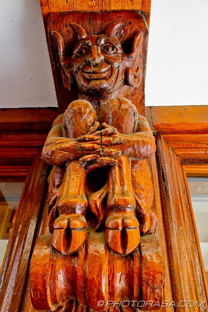 smiling satyre carved in wooden wall post