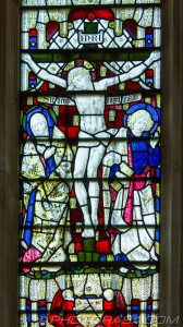 chancel window detail showing jesus on the cross with mary and beloved disciple mournfully looking away