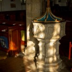 sun cast through windows on 14th century church font
