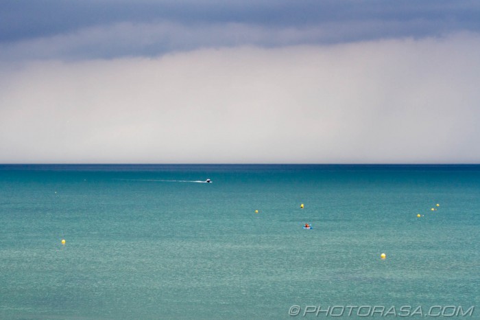 buoys and boats on stormy blue sea