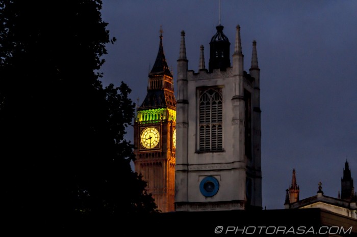 big ben between the trees and buildings