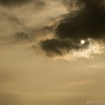 sun behind a dark cloud