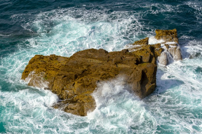 costal rock engulfed by waves
