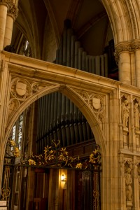 stone archway in front of organ pipes